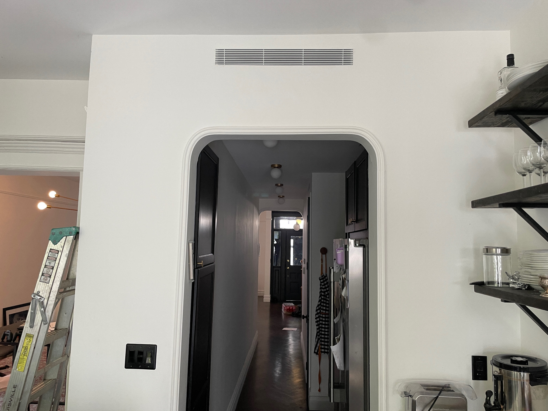 Linear grille above an arched cased opening